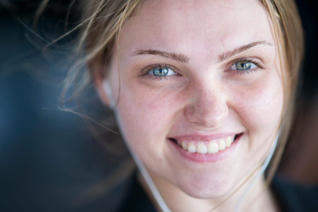Cheerful young woman smiling warmly at the camera for a close-up portrait.