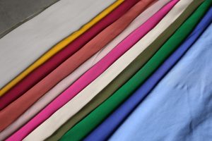 Vibrant fabrics arranged in a rainbow pattern showcasing a spectrum of colors.